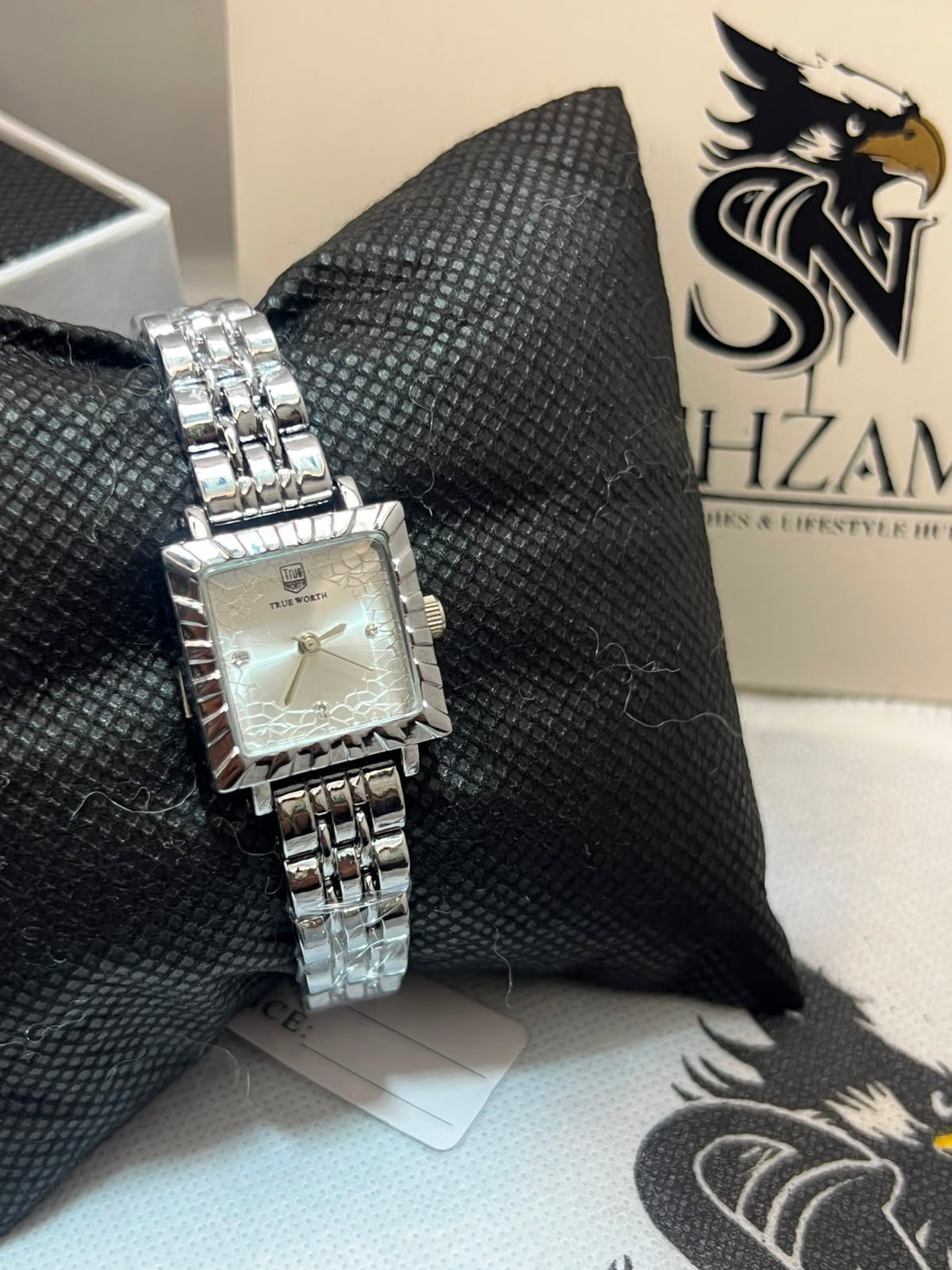 True Worth Ladies Square Watch showing silver floral dial with crystal markers and brick-link bracelet on black pillow