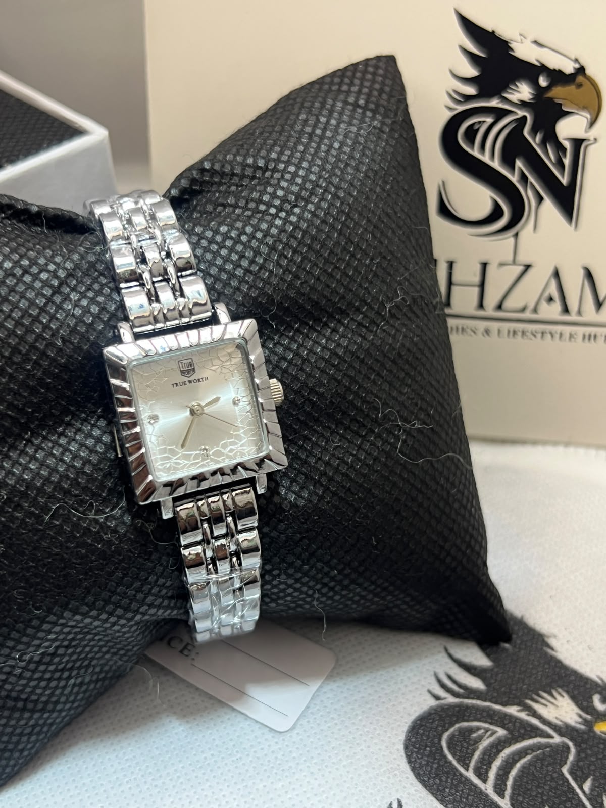 True Worth Ladies Square Watch showing silver floral dial with crystal markers and brick-link bracelet on black pillow