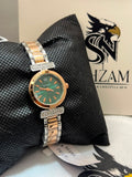 True Worth Ladies Quartz Watch front view showing emerald green dial with rose gold bezel and crystal lugs on black pillow
