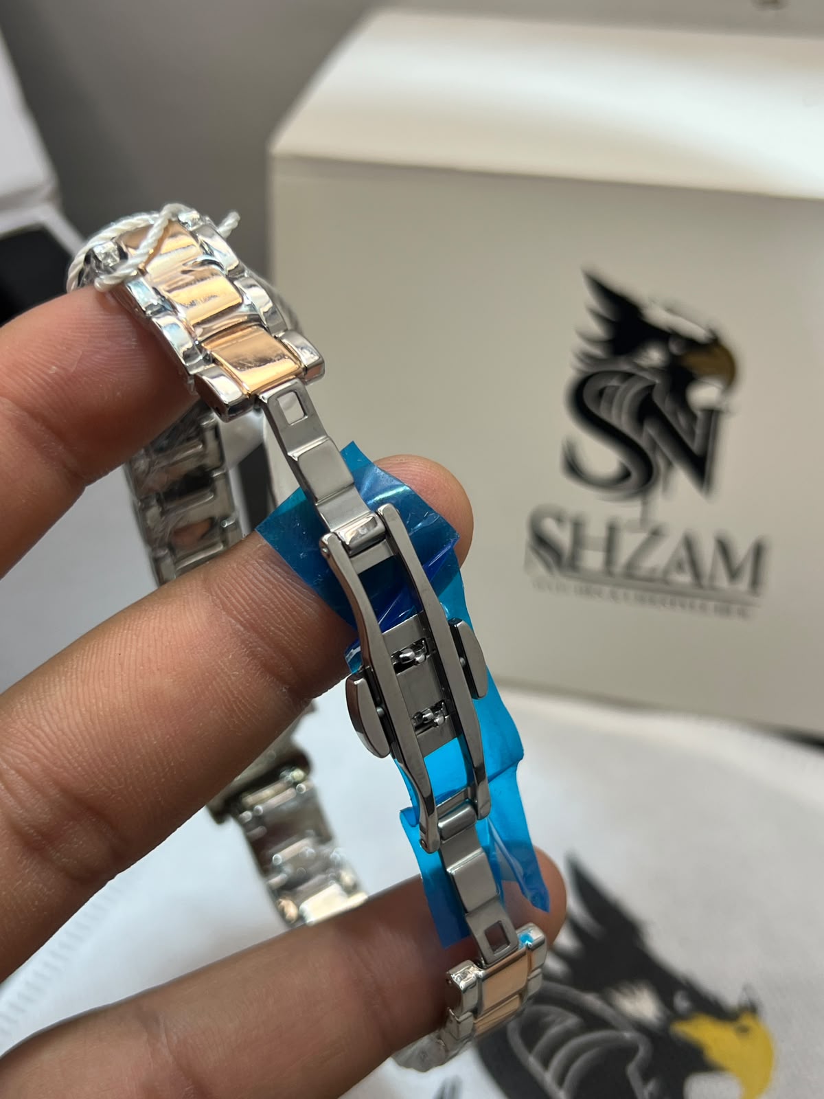 True Worth Ladies Quartz Watch butterfly deployment clasp detail held in hand with Shzam box in background
