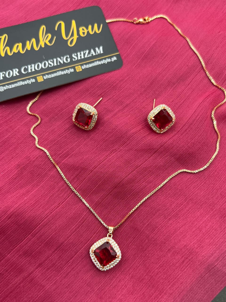 Ruby Red Square Crystal Halo Necklace and Earrings Set on red fabric