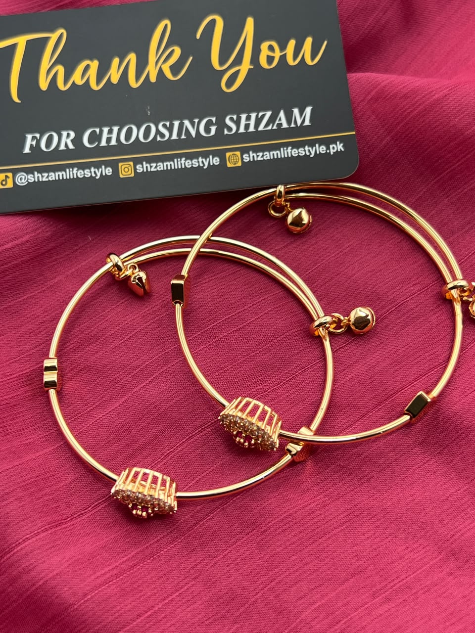Gold Crystal Flower Cuff Bangle Pair showing both Ruby Red and White variants on pink fabric