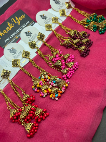 Emerald Green Antique Gold Tiered Jhumka Chandelier Earrings on pink fabric with Shzam thank you card