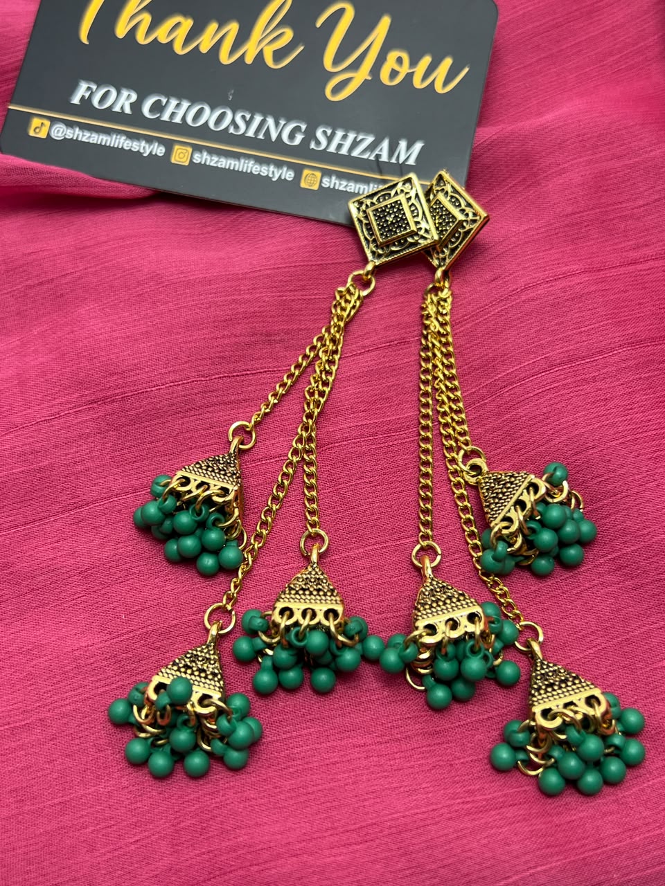 All 5 colors of Antique Gold Tiered Jhumka Earrings displayed on Shzam cards on pink fabric