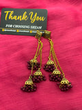 Maroon Wine Antique Gold Tiered Jhumka Chandelier Earrings on pink fabric
