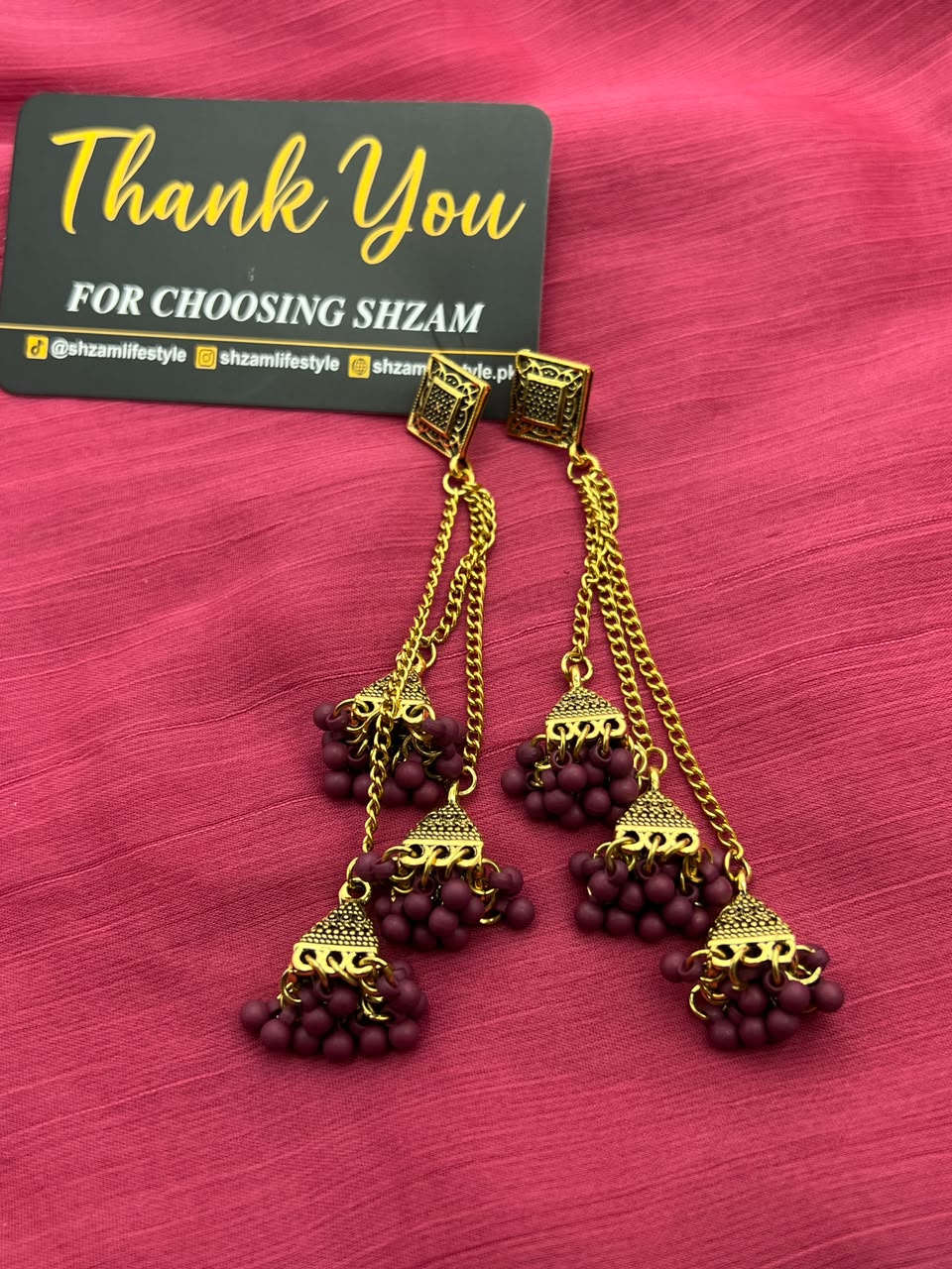 Maroon Wine Antique Gold Tiered Jhumka Chandelier Earrings on pink fabric