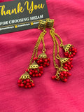 Red Antique Gold Tiered Jhumka Chandelier Earrings on pink fabric