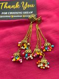 Multi-Color Antique Gold Tiered Jhumka Chandelier Earrings on pink fabric