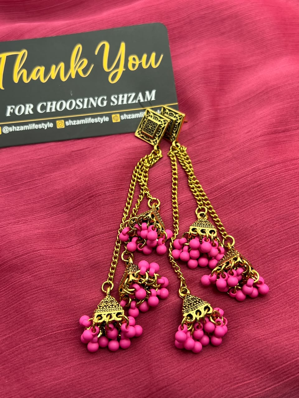 Hot Pink Magenta Antique Gold Tiered Jhumka Chandelier Earrings on pink fabric