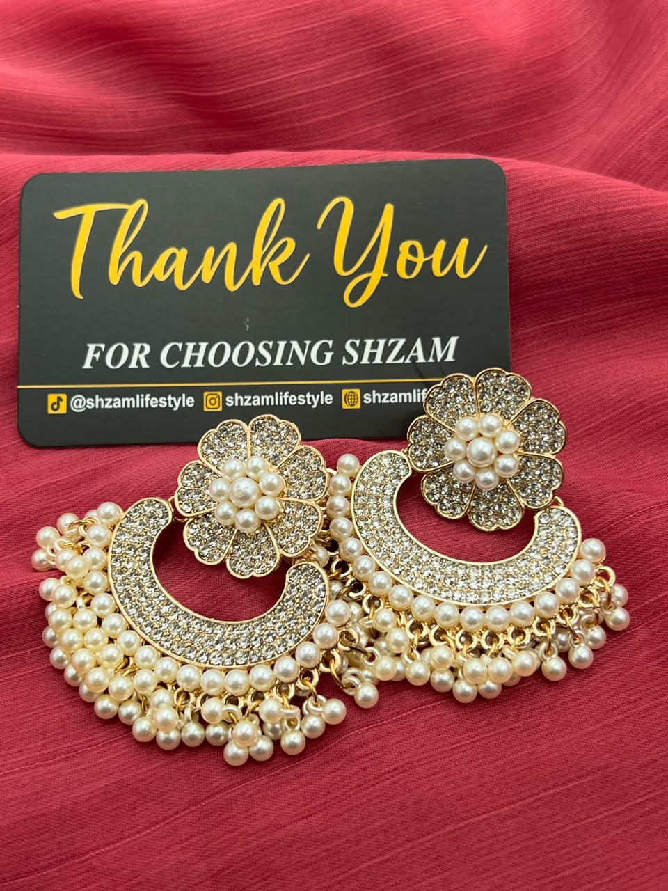 Pearl Chandbali Flower Earrings front view showing crystal flower top and pearl fringe on pink fabric