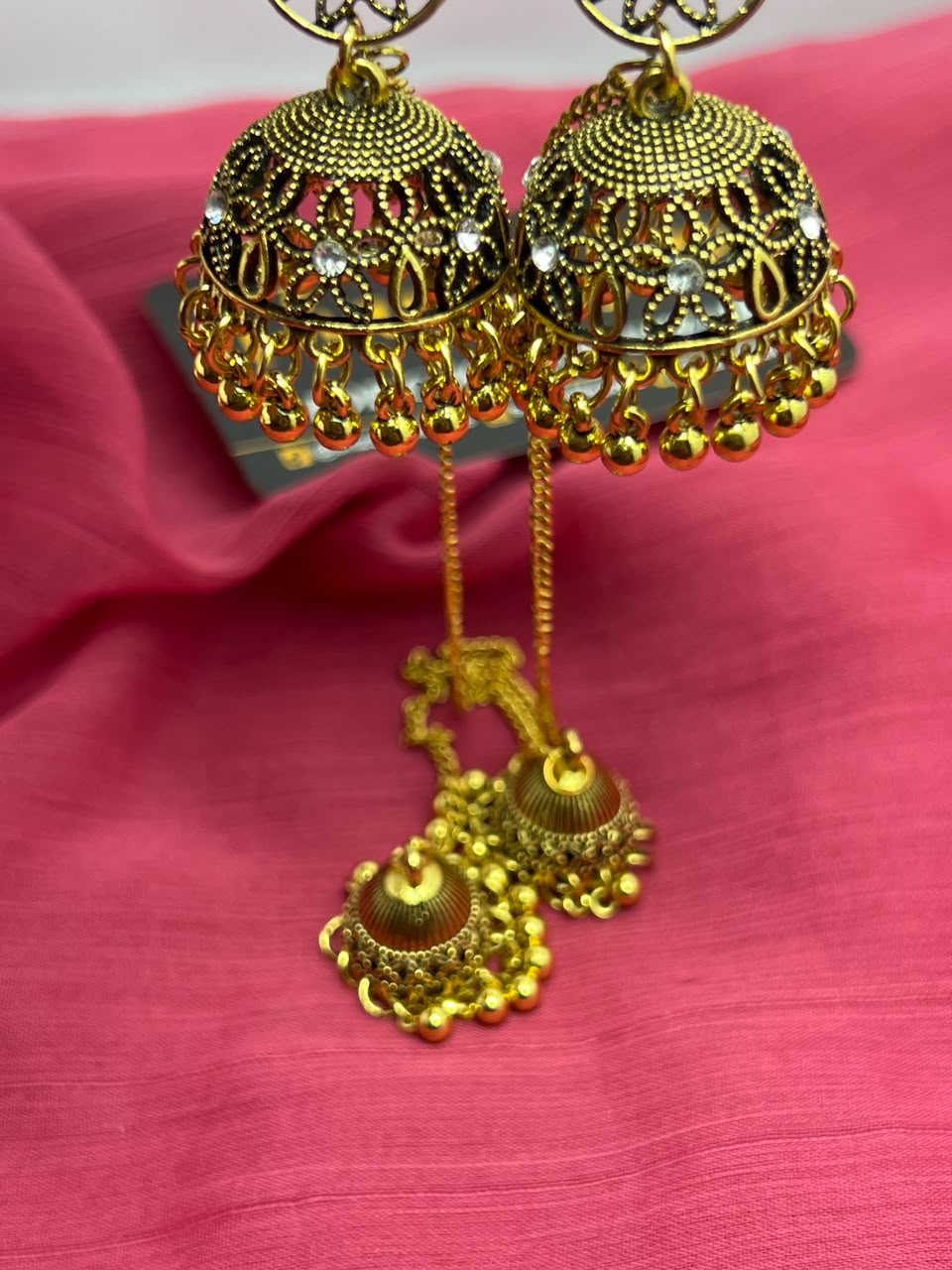 Antique Gold Jhumka Earrings close-up showing filigree cutwork crystal accents and gold ball fringe